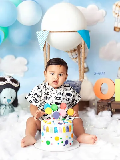 On cloud nine with his colourful birthday cake! This hot air balloon themed cakesmash is full of whimsy and fun. The bright polka dots on the cake add another pop of joy to the celebration.