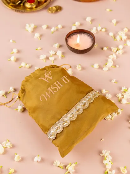 Old-school thamboolam gets a modern upgrade. This elegant potli, surrounded by fragrant jasmine, is a simple yet beautiful way to thank your wedding guests.