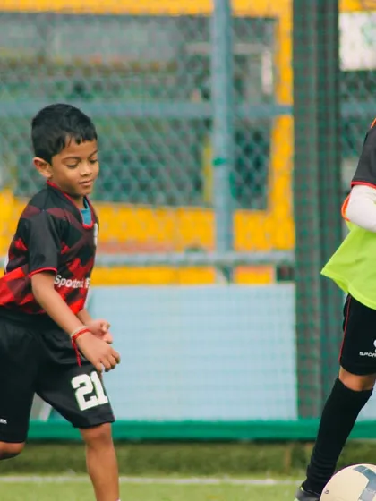 Here you can see two of our young players in a practice match, one focused on defending while the other controls the ball. This is where they learn to apply their skills.