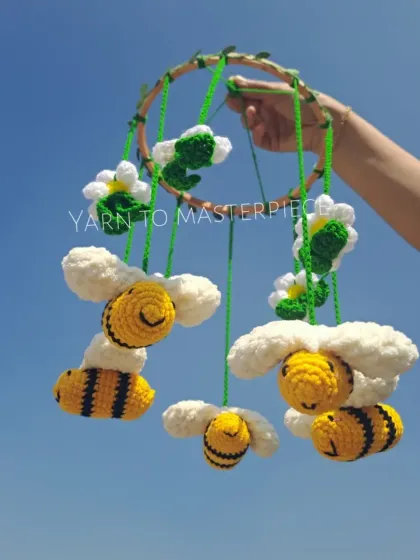 This honey bee-themed cradle mobile is so cheerful. It features buzzing bees, fluffy clouds, and flowers, all hanging from a leafy hoop.
