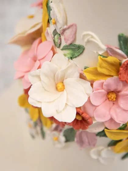 The beauty is in the details. This is a close-up of the hand-piped buttercream flowers on a wedding cake. Each petal is individually crafted, creating a garden of textures and soft colors that make the cake a true work of art.