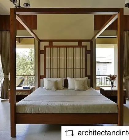 This weekend home in Khandala features a master bedroom with a classic four-poster bed. Large glass doors on either side open onto balconies, offering picturesque views of the valley and flooding the room with natural light.