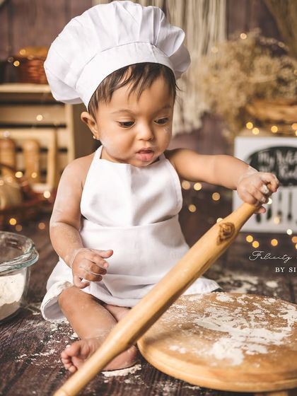 This little chef is hard at work with his rolling pin! I love creating detailed setups that allow for playful and candid moments like this.