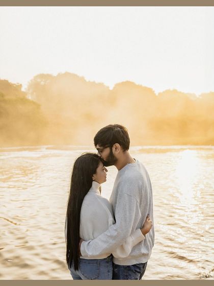 A beautifully composed silhouette-style shot with a golden glow, capturing a tender moment between the couple.