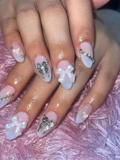A dreamy, princess-inspired set with a baby blue ombre, 3D bows, and rhinestone details. This is a popular style for clients who love feminine and elaborate designs.