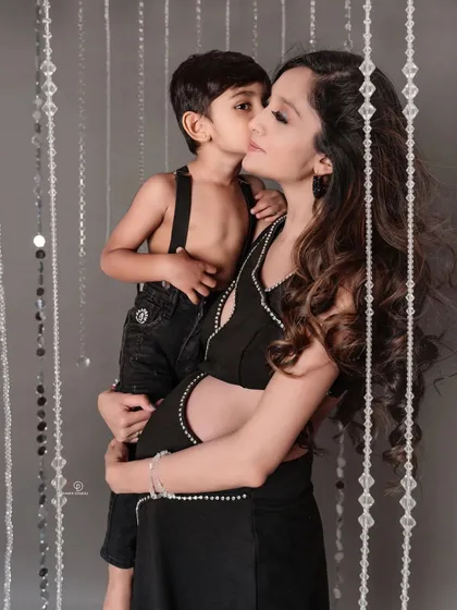 A mother's love is everything. This glamorous shot captures a tender kiss between a mom and her son as they celebrate the baby on the way.