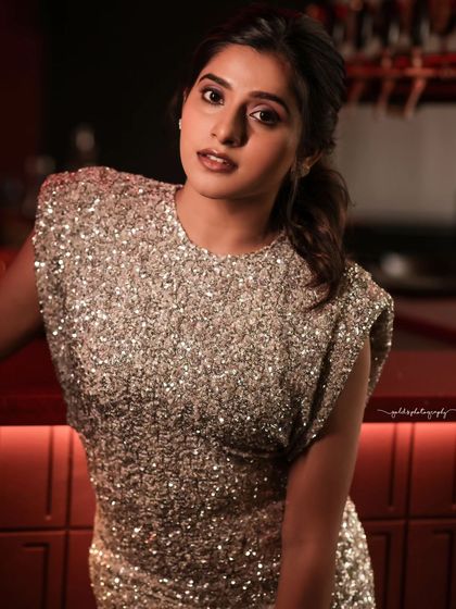 A close-up and a crouching pose from a glamour shoot. The focus is on the model's confident expression and the texture of the sequined dress, highlighted by dramatic studio lighting.