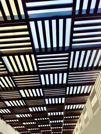 A close-up view of a rafter ceiling with a unique alternating pattern. This detail shot highlights the precision of our fabrication and the artistic possibilities of a custom pergola design.