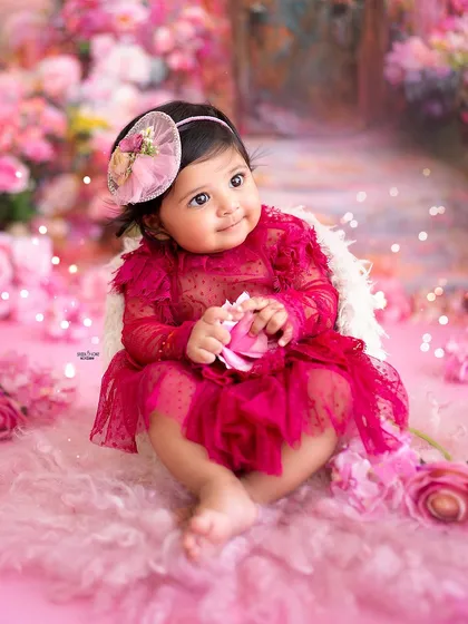 A sweet moment of her holding a pink flower, looking like a little pixie in her garden.