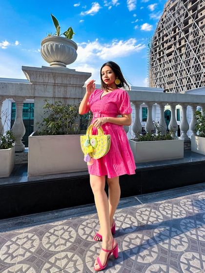 A confident pose in my pink summer dress. The v-neckline and belted waist are flattering details that I always look for.