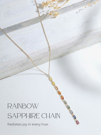 A product shot of the Rainbow Sapphire Chain, which radiates joy in every hue. The vertical pendant features a gradient of colorful sapphires.