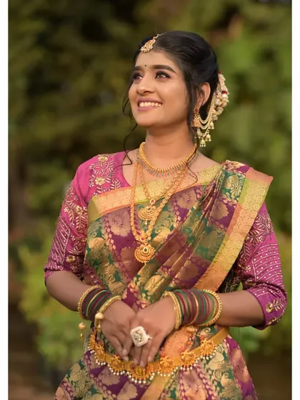 A glowing smile that completes the South Indian look. The makeup features golden tones and a defined eye to match the richness of the silk saree and gold jewelry.