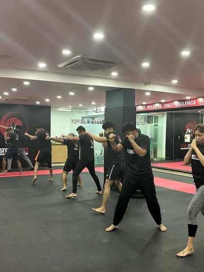 The class practices shadowboxing in unison, a fundamental drill for improving technique and footwork.