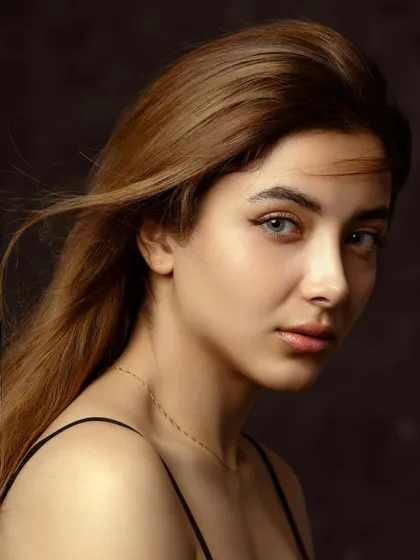 This is where simplicity meets soul. A classic studio headshot where the focus is entirely on the subject's expressive eyes and serene confidence, captured with soft, cinematic lighting.