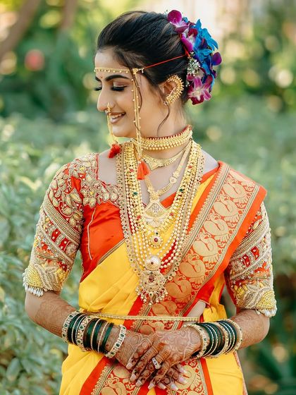 A beautiful side-profile of a Maharashtrian bride. This shot highlights her intricate hairstyle, adorned with flowers, and her traditional gold jewelry.