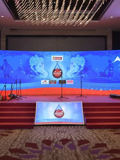 The stage for a corporate seminar, featuring a large, curved LED screen with clear branding and professional lecterns. The setup is clean, modern, and designed for effective communication.