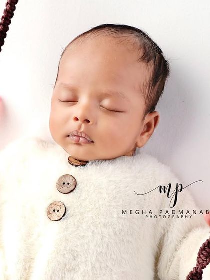 A detailed close-up of the baby's face on the swing.