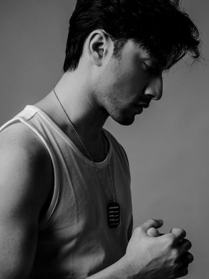 A pensive black and white profile shot of Lakshya in the classic tank top look.