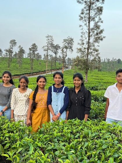 A group of friends from the KRIES camp poses for a picture in the beautiful tea gardens of Coorg.