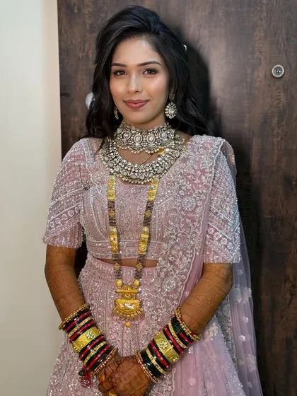 A bride in a pastel pink lehenga, with a traditional mangalsutra, blending modern and traditional elements.