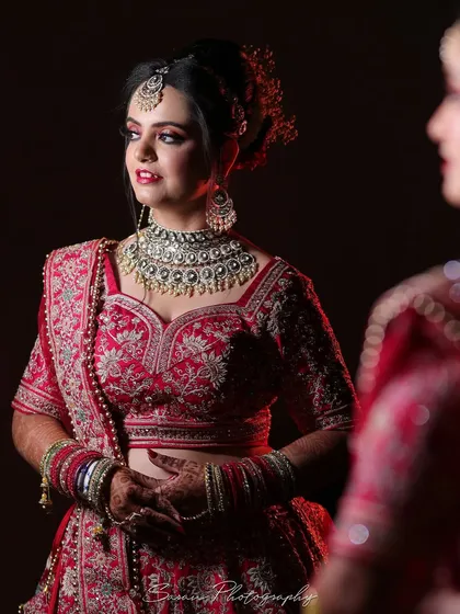 A beautiful shot of the bride looking at her reflection in the mirror, capturing a moment of quiet contemplation.