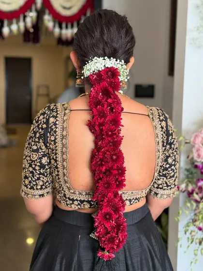 A full and voluminous traditional braid made entirely of fresh red flowers, paired with a classic jasmine gajra at the base. A stunning choice for a Muhurtham.