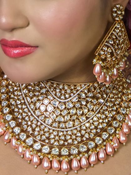 A close-up view of a stunning, wide Kundan choker with pink pearl drops. The intricate work and high-quality stones give it a luxurious, designer feel.