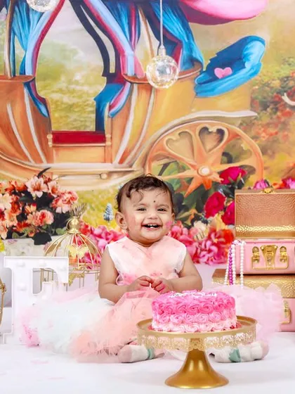 A fairytale first birthday for a little princess. This elaborate setup features a royal carriage backdrop, a pink castle cake, and plenty of sparkle for a magical celebration.