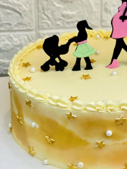 A close-up of the cute family silhouette toppers on the baby shower cake.