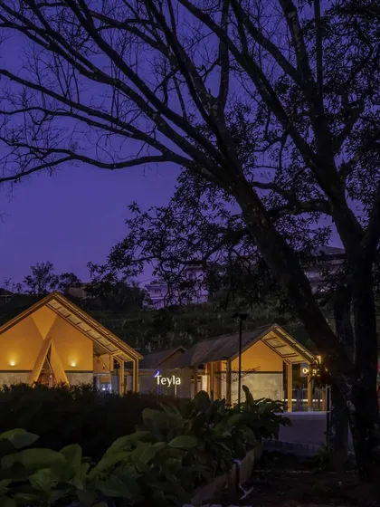 The Teyla tea shop at night, nestled in its environment, offering a warm and welcoming glow.