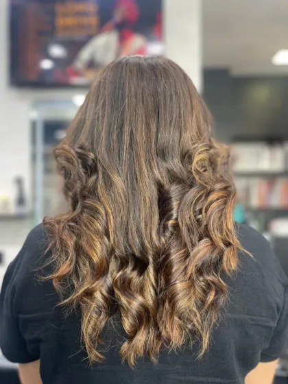 The back view of a gorgeous hairstyle with voluminous curls and rich, warm highlights.