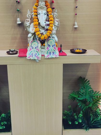 Small artificial plant arrangements placed on either side of a prayer altar. They add a touch of green that always looks fresh.
