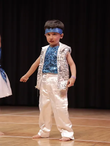Confidence on stage. This young performer from the 'Dancing Rockets' is ready for his moment in the spotlight, showcasing the results of our performance training.