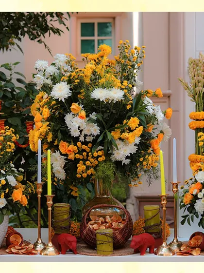 A tablescape featuring a mix of yellow and white flowers, with yellow candles and small decorative bears, adding a playful touch.