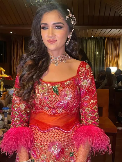 A glamorous sangeet look with side-swept waves and a statement hair accessory.