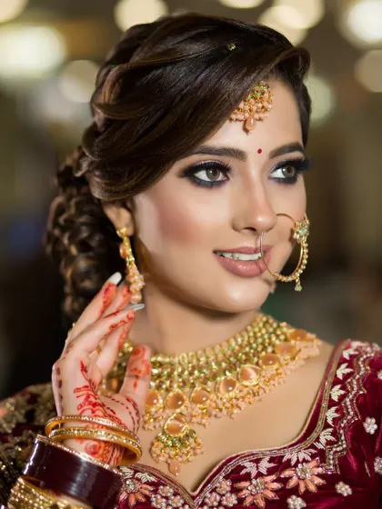 A classic bridal pose. The makeup is timeless, with a focus on bright, open eyes and a flawless complexion that looks stunning with gold jewelry.