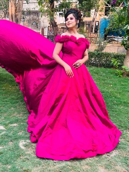 Three angles of our vibrant magenta off-shoulder gown with a long trail. These photos showcase its stunning color and dramatic flair, perfect for outdoor pre-wedding shoots.