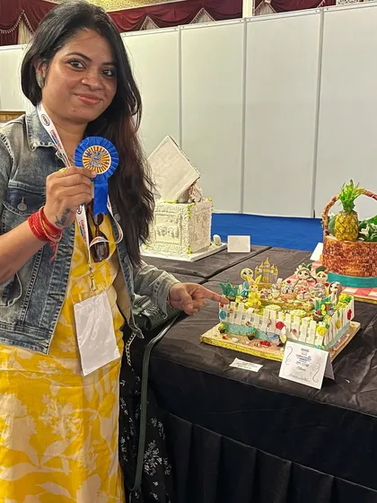 Proudly pointing to my award-winning cake at the competition.