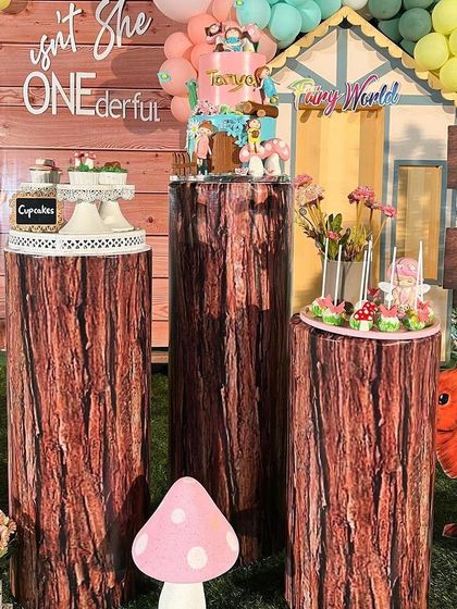 The dessert station with cake and cupcakes displayed on pedestals designed to look like tree trunks, perfectly matching the forest theme.
