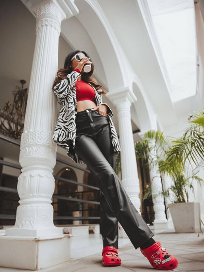 A low-angle shot that makes the outfit look even more powerful. This perspective highlights the red Crocs, making them the focal point of this chic, urban look.