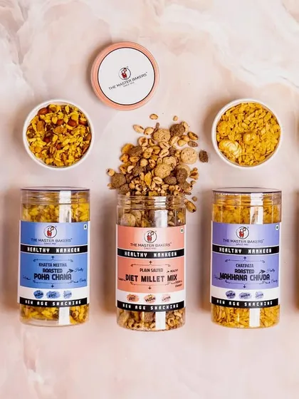 A top-down view of our healthy namkeen collection, showcasing the variety of guilt-free snacks we offer. This assortment includes Roasted Jowar Chivda, Diet Millet Mix, and Sweet Puff Mix, all packed in convenient, transparent jars.