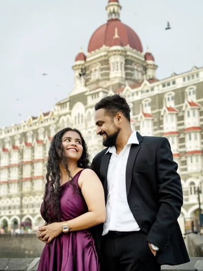 A classic romantic portrait of a couple in front of the Taj Mahal Palace Hotel, a timeless pre-wedding photograph.
