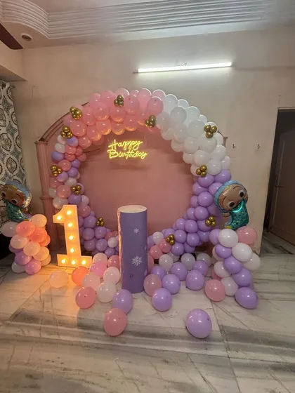 A wider view of the pastel Cocomelon first birthday, showing how the balloons fill the space around the arch.