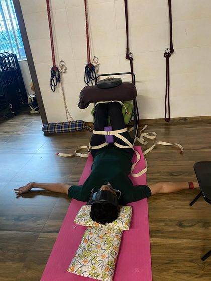 A Sunday relaxing session. The student is in a supported Viparita Karani (Legs-up-the-Wall Pose) with weights and belts to ground the body and quiet the mind.