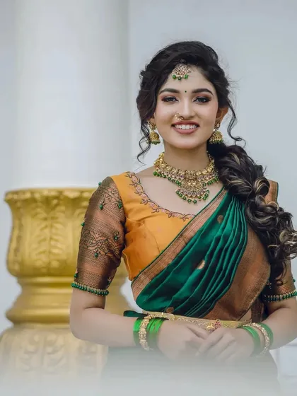 I love how the vibrant green stones in this antique-style necklace pop against the traditional silk half-saree. This is a great example of how my Kempu and colored stone sets can add a beautiful splash of color to your photoshoot, making the images lively and memorable.