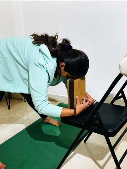 Using props like a chair and block allows for a deeper, more restorative stretch in poses like Parsvottanasana (Pyramid Pose). This helps to safely lengthen the spine and hamstrings, which is key for alleviating back pain.