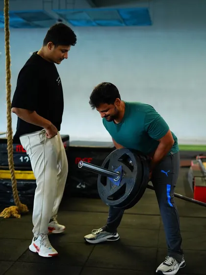 The perfect rep requires precision. Here, one of our trainers provides real-time feedback on a bent-over row, ensuring proper form to maximize muscle engagement and prevent injury.