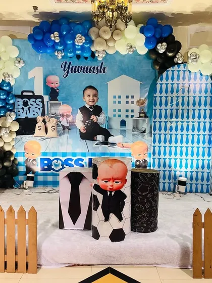 Our popular Boss Baby theme, perfect for a little one's big day. This stage setup includes a personalized backdrop, character cutouts, a multi-toned blue, black, and silver balloon arch, and themed props to create a fun, corporate-inspired party.