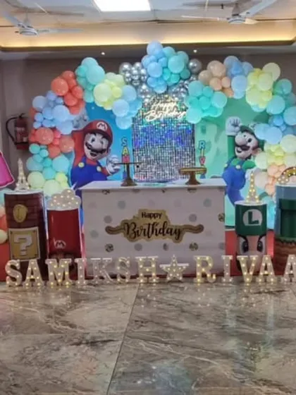 It's-a-me, Mario! A Super Mario themed birthday party with all the favorite characters like Mario, Luigi, and Princess Peach. The setup includes game-inspired props and a colorful balloon backdrop.
