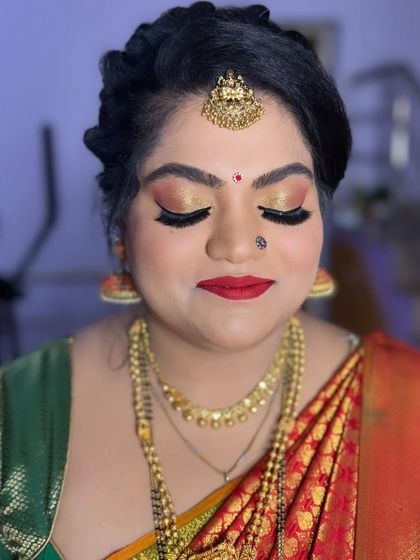 The client looks absolutely radiant with her requested glittery eye makeup and red lip.